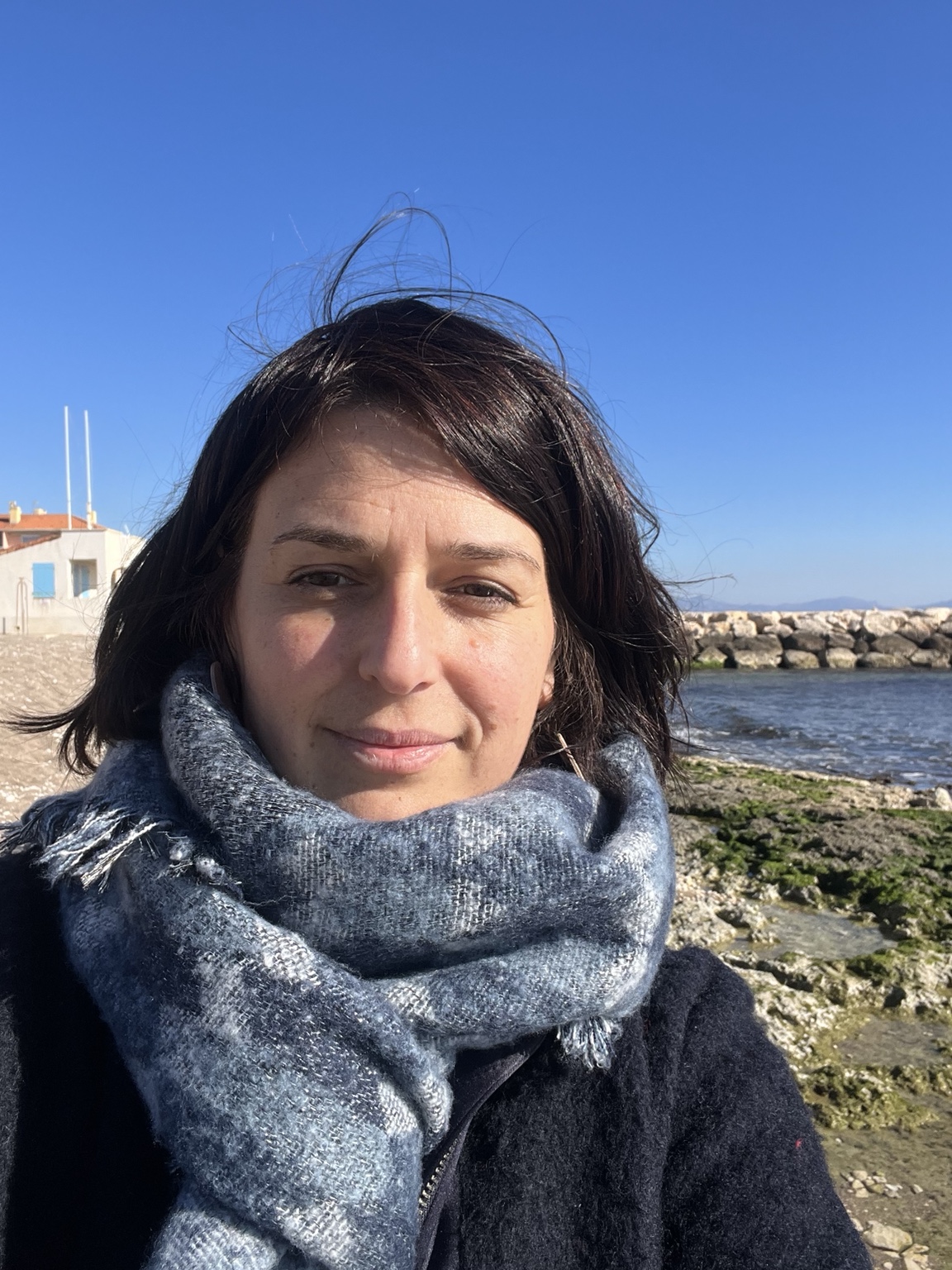 Portrait de Julie Lenoble avec une écharpe, au bord de la mer